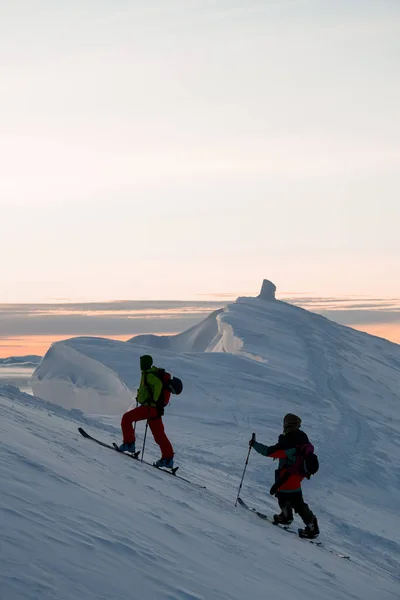 Dois esquiadores subir até o topo de uma encosta de montanha nevada — Fotografia de Stock
