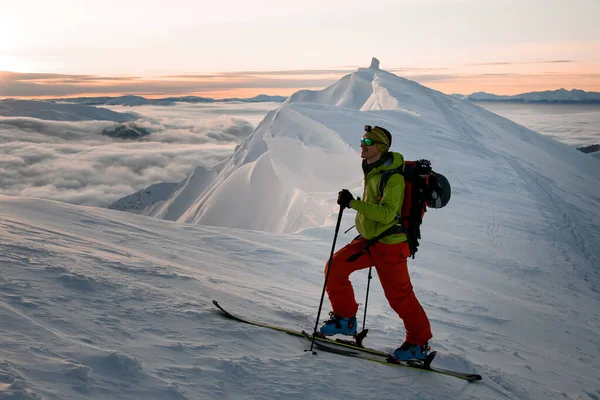 Gülümseyen erkek kayakçı gökyüzü ve bulutların manzarasının arka planında — Stok fotoğraf