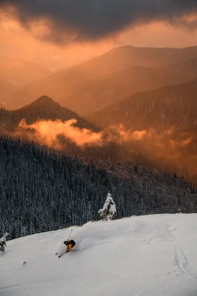 Síelő lovagol lejtőn hátterében téli hegyi táj fényes ég — Stock Fotó