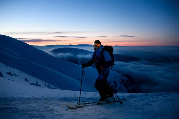 Skieur homme avec une lampe de poche sur le front sur fond de ciel nocturne pittoresque — Photo