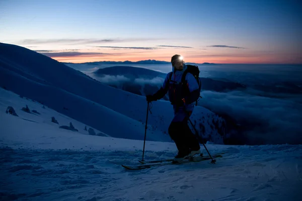 Лыжник с фонариком на лбу на фоне живописного вечернего неба — стоковое фото