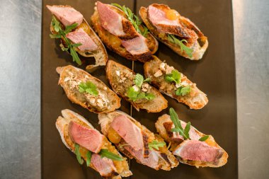 Maydanoz ve roka ile süslenmiş sebzeli ve dilimlenmiş beyaz baget dilimlerinin üst görüntüsü