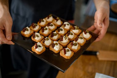 Erkeklerin elindeki tepside nefis bir bruschetta.