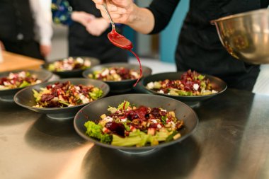 Yemek pişirme işlemi - salatayla tabağa kırmızı sos eklemek