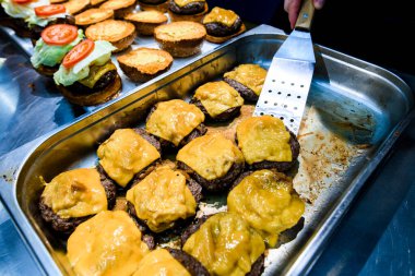 Fırında pişmiş pirzola ve erimiş peyniri metal bir kabın üzerinde görmek