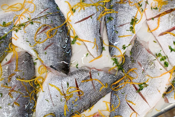 Close-up of slices of raw fish with cuts with grated carrots and herbs — Fotografia de Stock