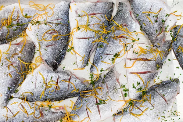 Beautiful close-up of slices of raw fish with cuts with grated carrots and herbs — Stock Fotó