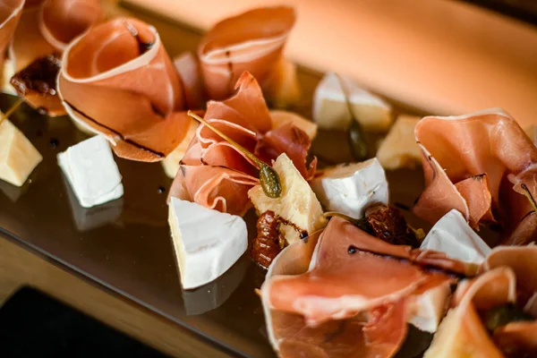 Zbliżenie na planie z kawałkami sera i plastrami prosciutto i salami — Zdjęcie stockowe