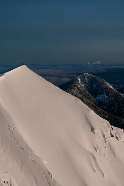 Maravilhosa vista aérea da encosta da montanha coberta de neve com o homem no topo. — Fotografia de Stock