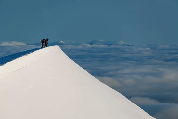 Great view of top of clear white snowy mountain slope with skiers on it — стоковое фото