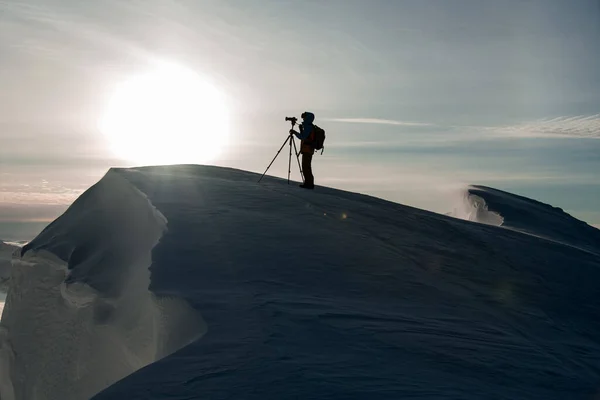 Sagoma di fotografo con macchina fotografica su pendio di montagna contro sfondo di cielo — Foto Stock