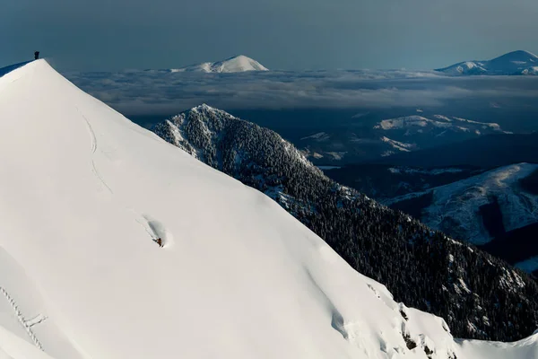 Grande vista da paisagem de inverno e topo da encosta da montanha com esquiador deslizando ao longo dele — Fotografia de Stock