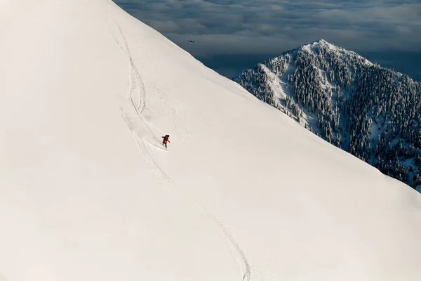 Vista maravilhosa da encosta da montanha e esquiador deslizando para baixo sobre ele. Conceito de esqui Freeride — Fotografia de Stock