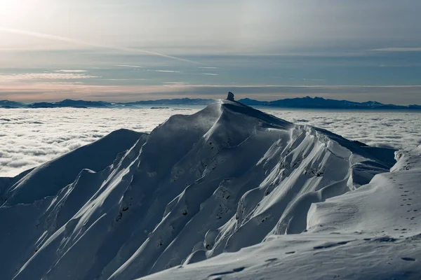 Vue fantastique sur la chaîne de montagnes enneigée entourée de nuages sur fond de ciel — Photo