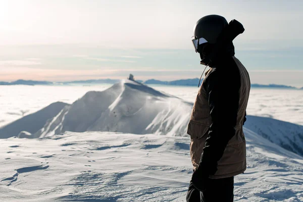 Side view of skier in ski suit and helmet against background of mountain landscape. — Stock Fotó