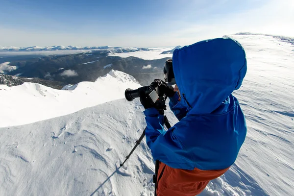 Close-up view of man with camera taking pictures of beautiful winter mountain landscape — Fotografia de Stock