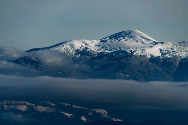 Vista aérea gloriosa da neve coberto montanha topo e paisagem pitoresca montanha inverno com coníferas árvores e nevoeiro — Fotografia de Stock