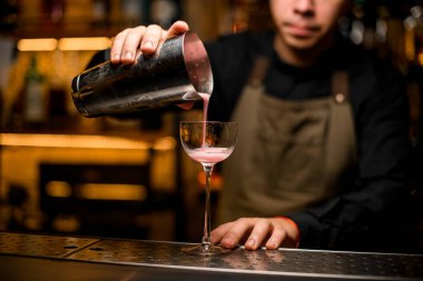 İçeceklerin karıştırıcıdan döküldüğü kokteyl bardağının manzarası harika.