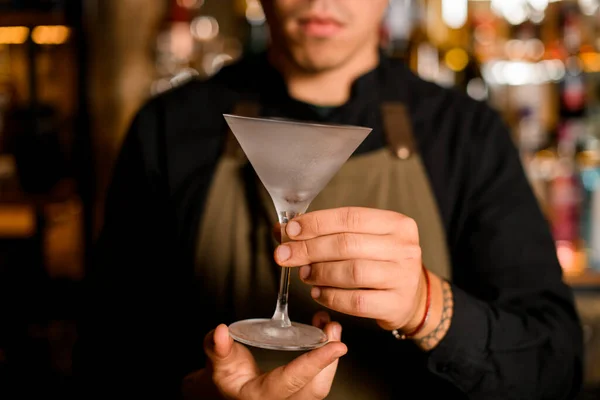 Крупным планом мужчины, держащего в руках красивый пустой бокал с мартини — стоковое фото