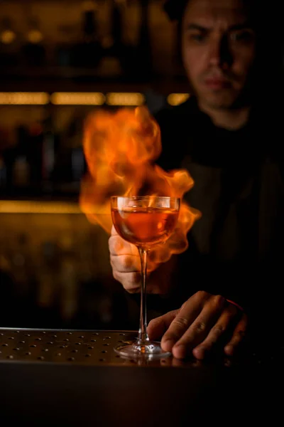 Copa de vino con bebida en el bar y llama ardiente está en el fondo — Foto de Stock