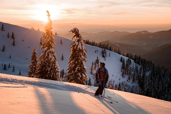 Człowiek freerider stoi na śnieżnym zboczu góry na tle pięknego górskiego krajobrazu. — Zdjęcie stockowe