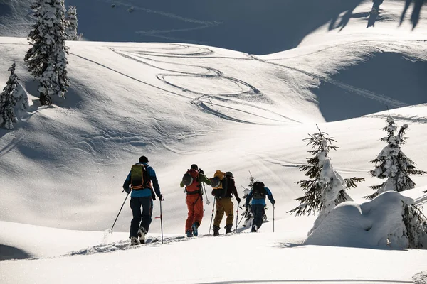 Wycieczka narciarska grupa osób ze sprzętem narciarskim spaceruje zimową śnieżną ścieżką na zbocze górskie — Zdjęcie stockowe