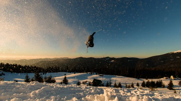 Gökyüzüyle karlı tepeden atlayan Freerider 'in harika manzarası. Arkasına kar sıçrattı.
