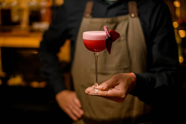 Bartender håller i händerna rosa cocktail dekorerad med frukt marshmallow. — Stockfoto
