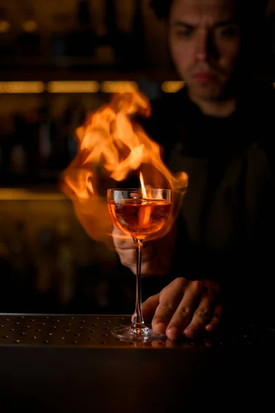 Der Barkeeper zündet ein Glas mit einem alkoholischen Getränk an — Stockfoto