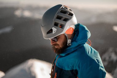 Güneş gözlüklü ve kayak kasklı sakallı adamın harika yan görüntüsü.