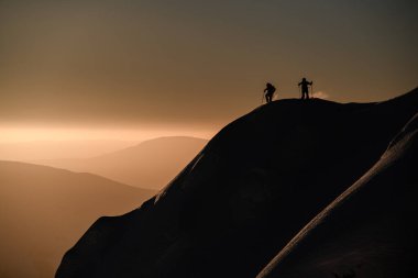 Üzerinde toz kar ve kayakçılar olan karla kaplı büyük bir tepe. Kayak turu ve serbest dolaşım konsepti