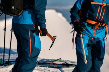 Bir kış manzarasının arka planına karşı insanların elindeki buz baltalarına odaklan
