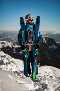 Bir kış dağ manzarasının arka planında kayak yapan insanların tam boy portresi.