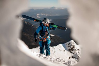 Mavi gökyüzünün arka planında parlak kayak takımlı bir adamın görüntüsü