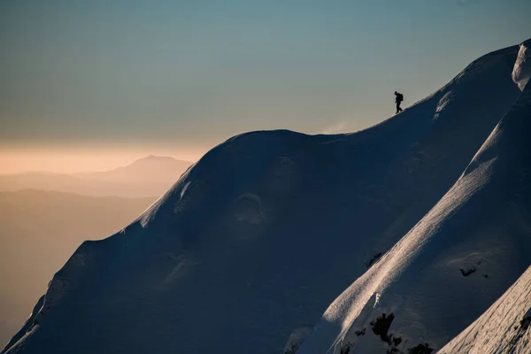 Karla kaplı tepelerde toz kar ve üzerinde bir adam kayakçı var. Kayak turu ve serbest dolaşım konsepti — Stok fotoğraf