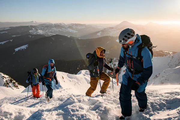 美しい冬の山の風景を背景に雪に覆われた山道を登る男性観光客のグループ — ストック写真