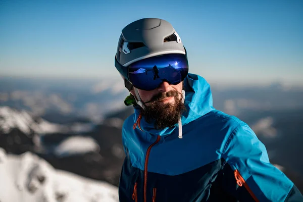 Retrato de homem com capacete de esqui e óculos contra um fundo embaçado — Fotografia de Stock