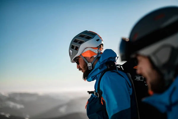 Kafasında kayak kaskı olan bir adamın mavi gökyüzü arka planına baktığını gördüm. — Stok fotoğraf