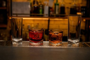 Bar tezgahında boş ve dolu bardaklar var..