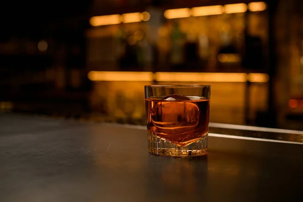 View of old-fashioned glass with a bright cold beverage stands on bar — Stock Photo, Image