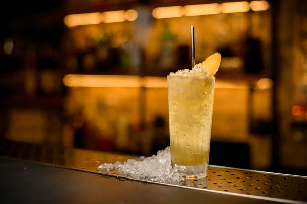 Geweldig vooraanzicht op cocktailglas met ijs gegarneerd met ananasschijfje en stalen drinkstro. — Stockfoto