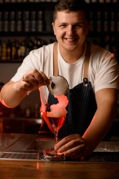 Erkek barmen bardağı beyaz köpüklü bir kokteyl ile güzelce süslüyor. — Stok fotoğraf