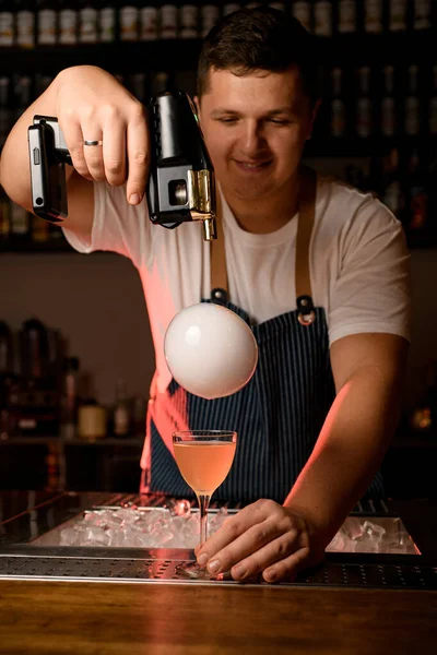 Vista de bolha com fumaça acima de vidro com coquetel e bartender com blaster sabor — Fotografia de Stock