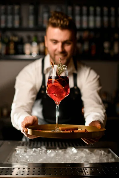 Hermosa copa con delicioso cóctel exclusivo en bandeja en las manos de un camarero masculino —  Fotos de Stock
