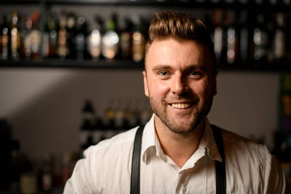 Porträtt av ung leende man bartender med snygg frisyr — Stockfoto