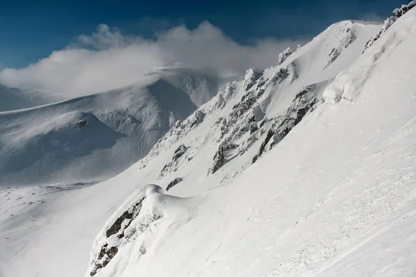 Pitorescas encostas de montanha são cobertas com neve branca e céu azul — Fotografia de Stock