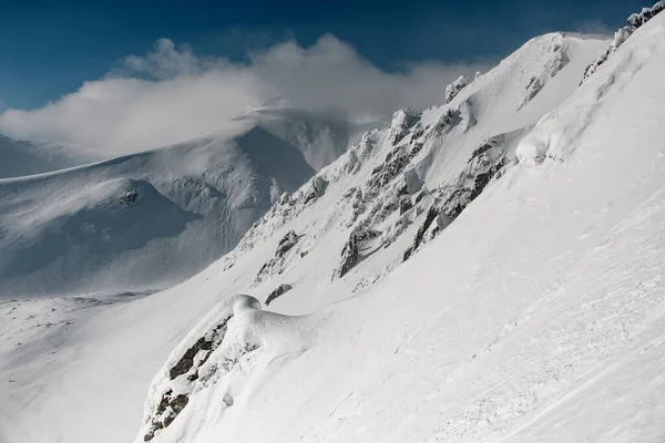 Picturesque mountain slopes are covered with white snow and blue sky — 스톡 사진