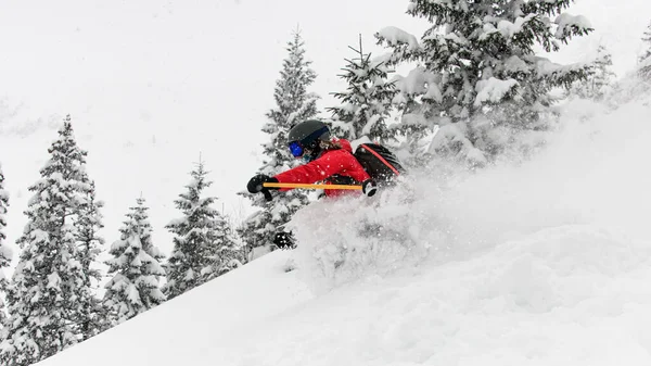 Vista de perto do esquiador descendo na encosta coberta de neve e salpico de neve ao seu redor — Fotografia de Stock