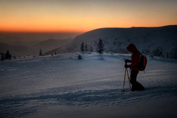 Widok z boku narciarz z sprzętu turystycznego chodzenie w głębokim śniegu na zboczu góry. — Zdjęcie stockowe