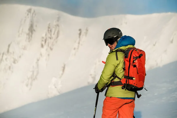 Rear view of a man in a ski jacket with a backpack who turned back — ストック写真